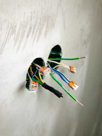 Several open and exposed wires hanging out from holes.