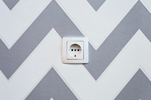 An electrical outlet placed on a painted wall.
