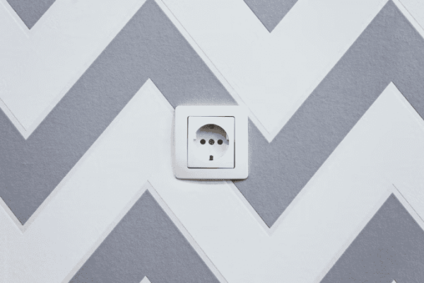 An electrical outlet placed on a painted wall.