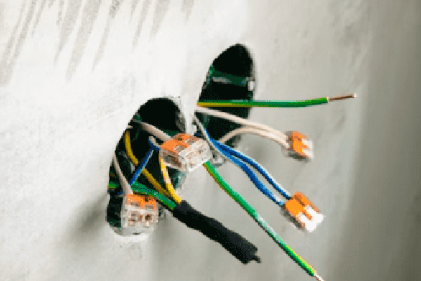 Several open and exposed wires hanging out from holes.